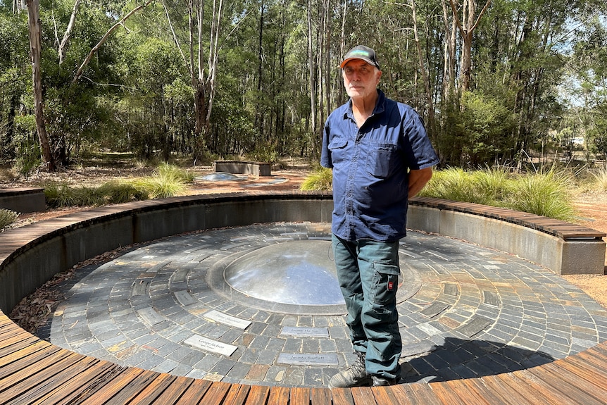 Un homme près du centre d'un mémorial circulaire avec des plaques