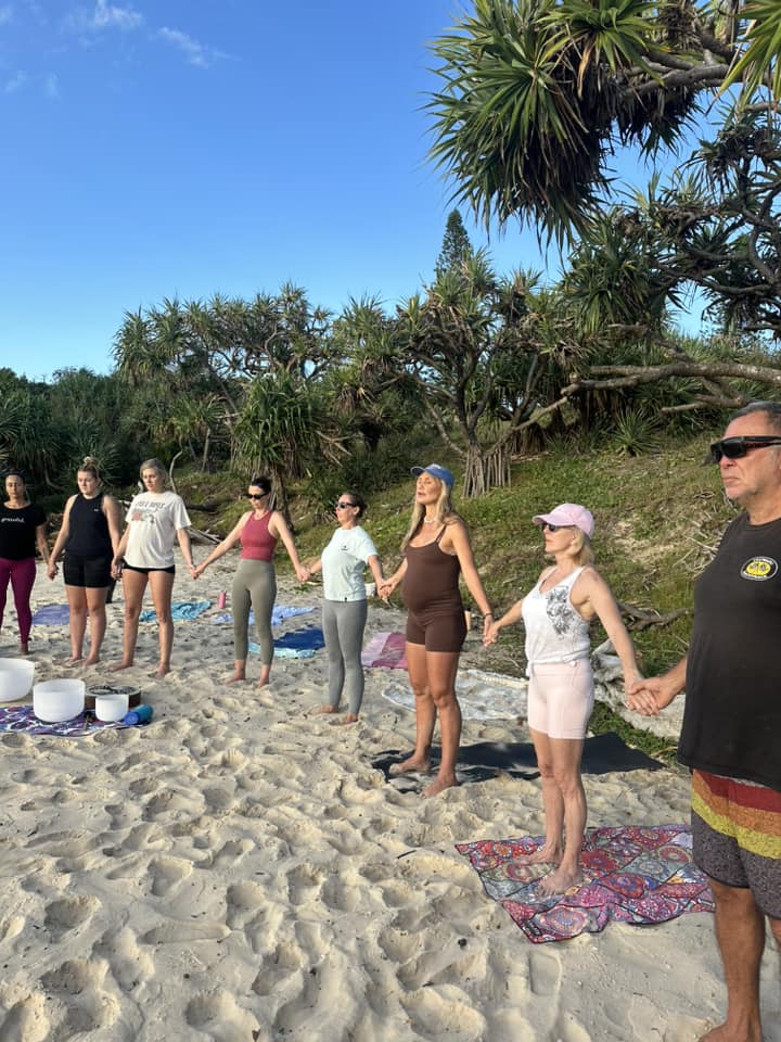 Group holding hand on beach.