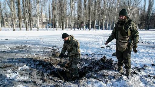 A Ukrainian soldier inspects a crater left by the explosion in Avdiivka.