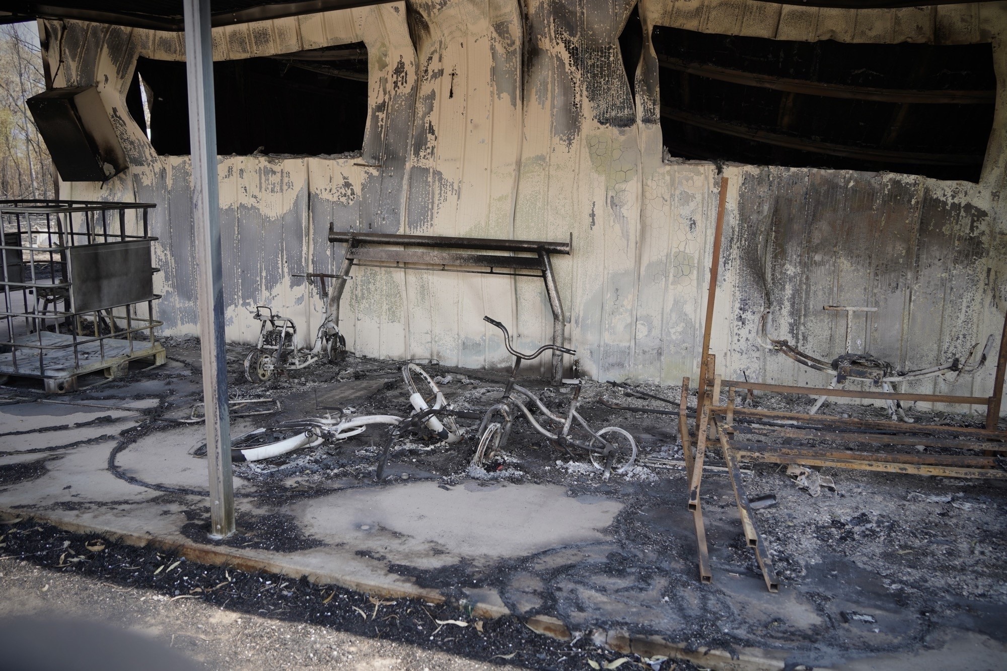 A burnt out bike sits on the porch of a home destroyed by fire in Tara.