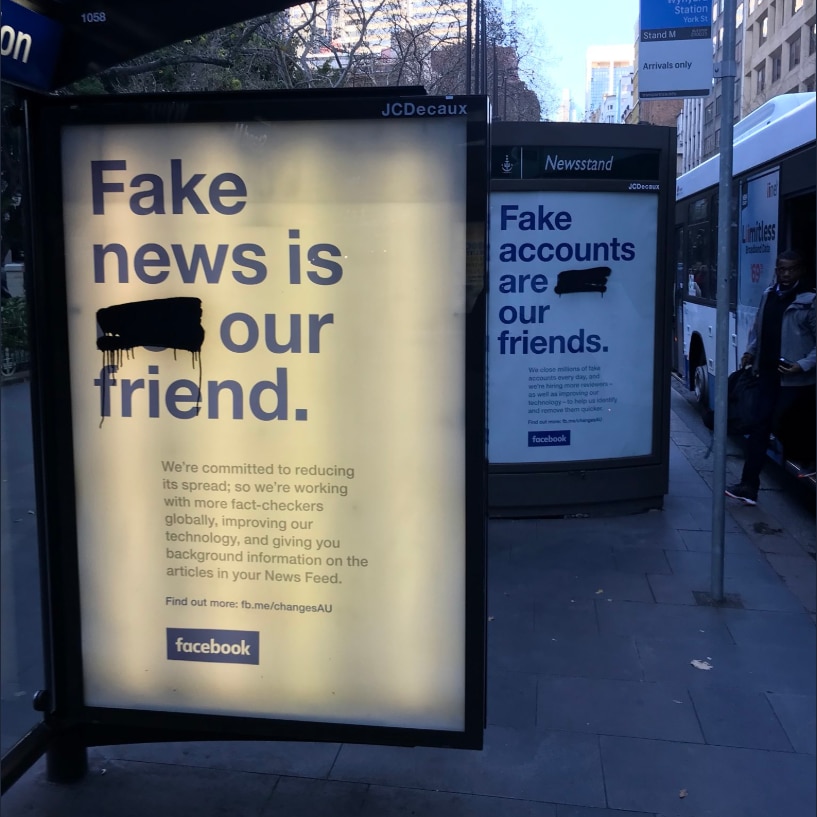 Defaced Facebook advertisement on bus shelter and news stand that now reads: "Fake accounts are our friends"