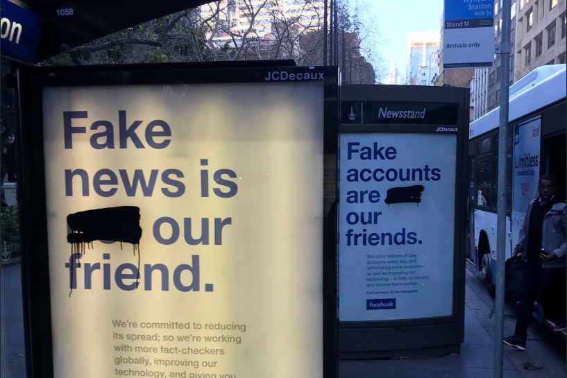 Defaced Facebook advertisement on bus shelter and news stand that now reads: "Fake accounts are our friends"
