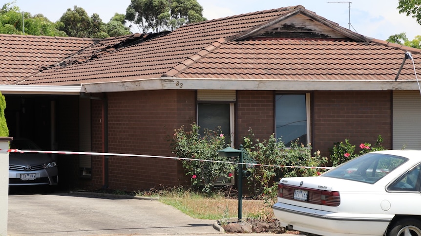 A brick veneer house with damage to the tile roof.