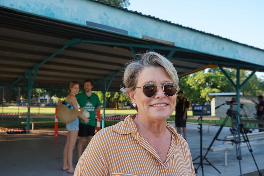 A photo of an older woman outside a primary school in Darwin.