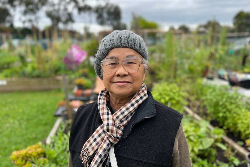 Kim Chua smiles standing in a garden.