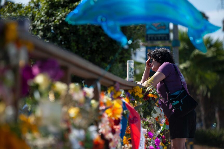 A woman gets emotional after placing flowers at a memorial for the victims of the Conception.