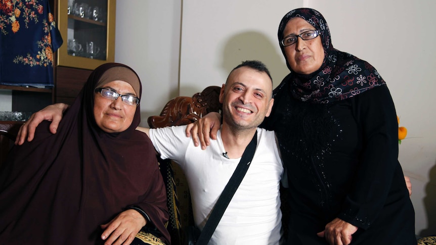 Amer Khayat, in a white t-shirt and shoulder bag, with sisters Nada and Imm Fayez, both wearing hijabs.