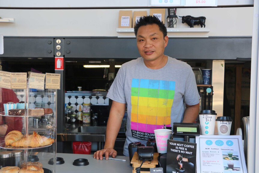Louis Lam stands at the counter in his coffee shop.