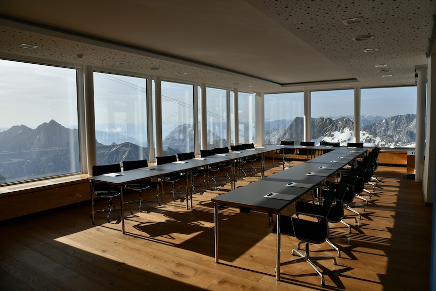 A standard looking conference or meeting room with stunning mountain ranges out every window