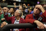 Disappointed share investors on a trading floor.
