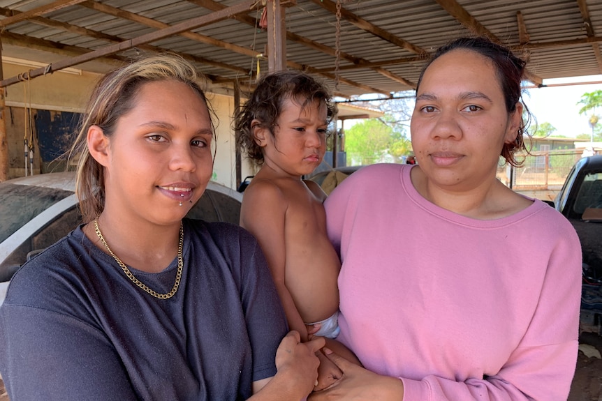 Kerrieanne Allen and Diane Derrick stand holding a child.