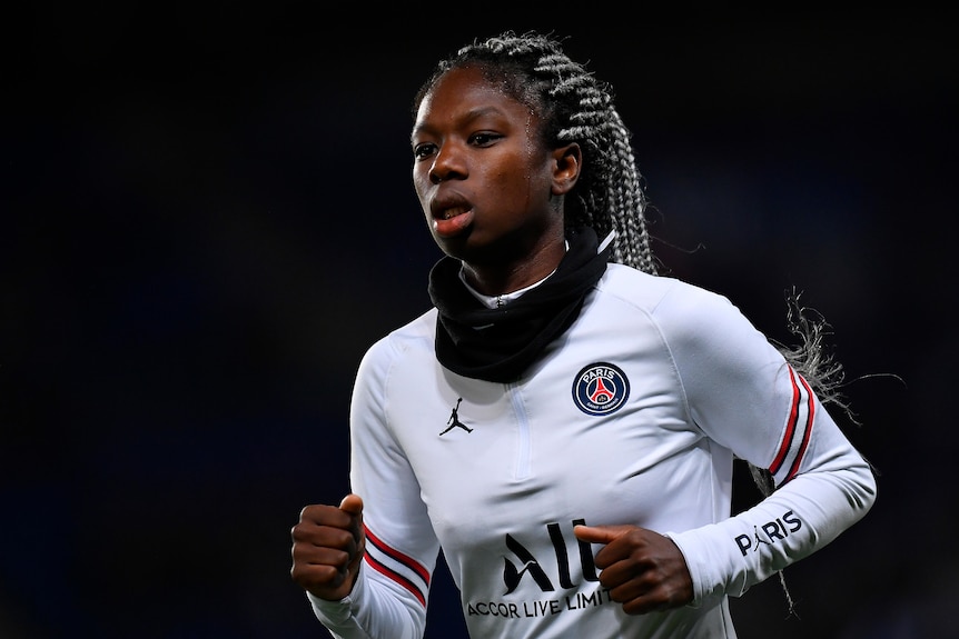 A picture of a footballer wearing a scarf around her neck, exercising before a big game.