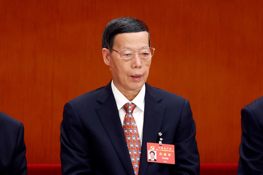 A picture of an older Chinese man with neat black hair and glasses