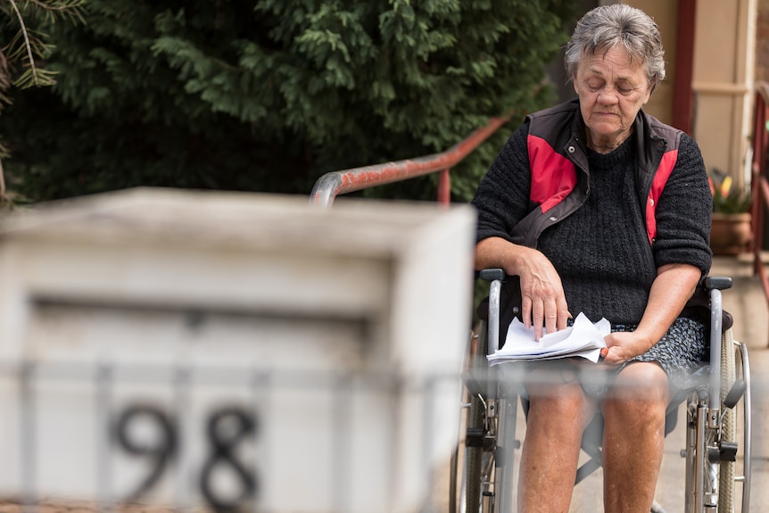 Kobieta na wózku inwalidzkim przeglądająca dokumenty