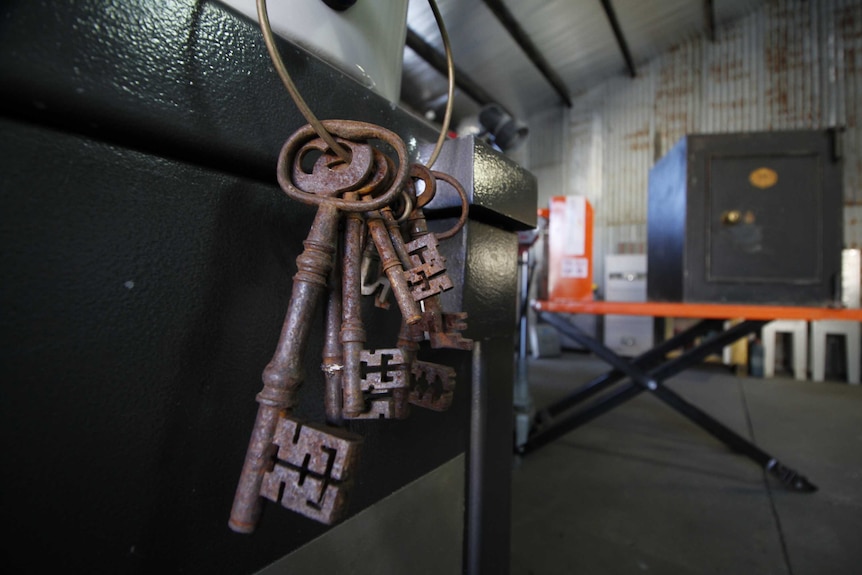 Close up of keys with an old safe in the background.