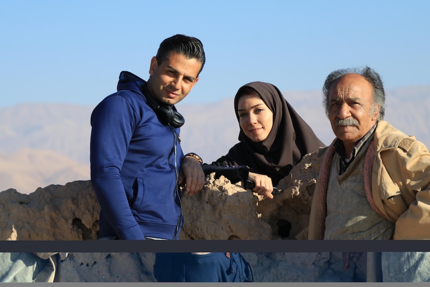 two men and a woman on a set in provincial Iran