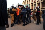 Men escorted into a van.