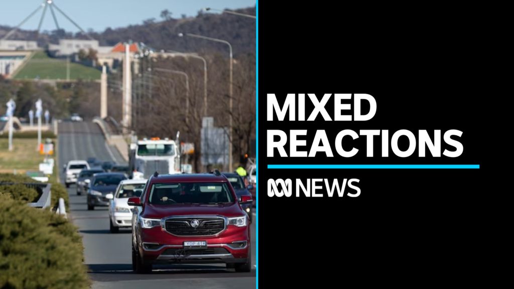 Mixed Reactions: Cars drive on a road with Parliament House in the background