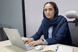 A young women in suit with a laptop 