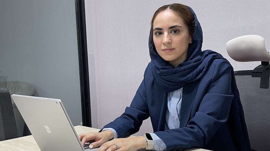 A young women in suit with a laptop 