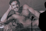 Arnold Schwarzenegger silhouetted in front of famous Burt Reynolds picture