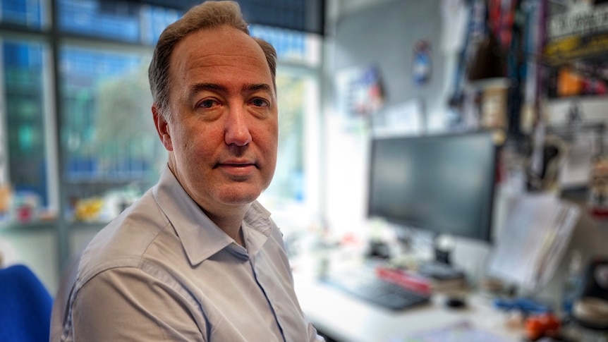 Michael Fitzharris wearing a blue shirt sitting in a chair