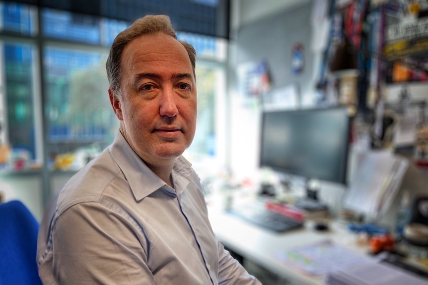 Michael Fitzharris wearing a blue shirt sitting in a chair