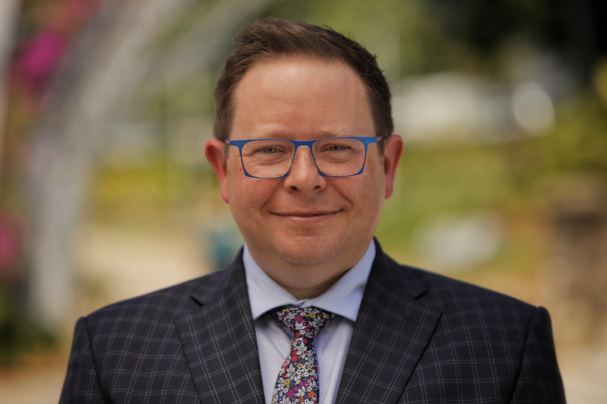 A man wearing a suit and glasses.