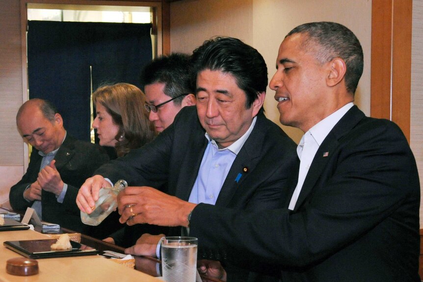 Japanese Prime Minister Shinzo Abe pours Mr Obama sake in Jiro sushi