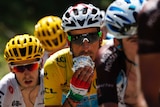Fabio Aru eating a snack while riding in the yellow jersey at the Tour de France.