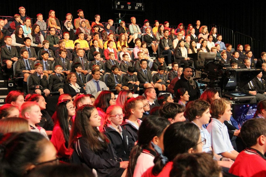 High school students sitting in a television studio audience.