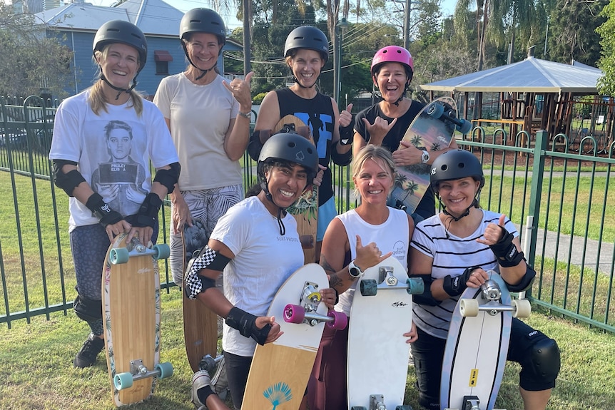 Group of woman in skate helmelts with skateboards