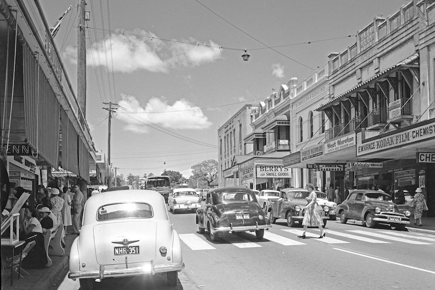 A black and white photo of a busy street. 