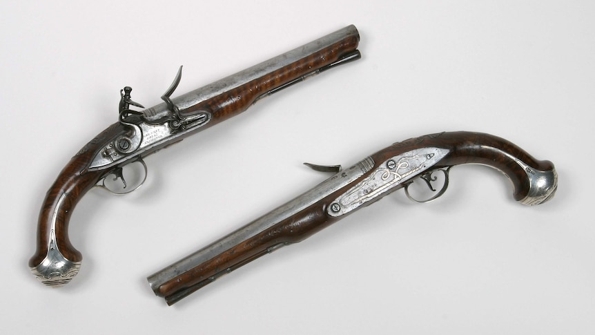 two vintage pistols against a white background