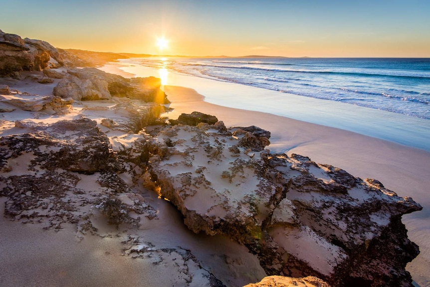 A sunrise over the beach and water at Sleaford Bay, in Lincoln National Park on the Eyre Pensinsula, SA.