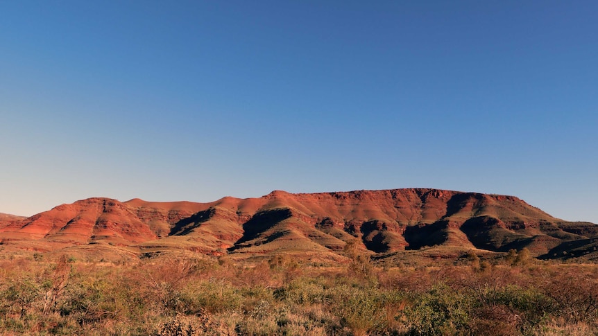 The red, rocky Hamersley Range, Pilbara, Western Australia under a deep blue sky.