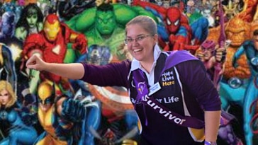 woman in cancer council outfit in front of wall of superheros