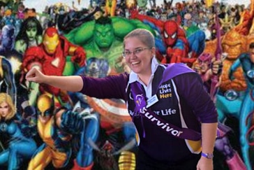 woman in cancer council outfit in front of wall of superheros