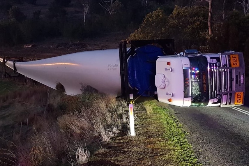A rolled over truck carrying an 80-metre wind turbine blade.