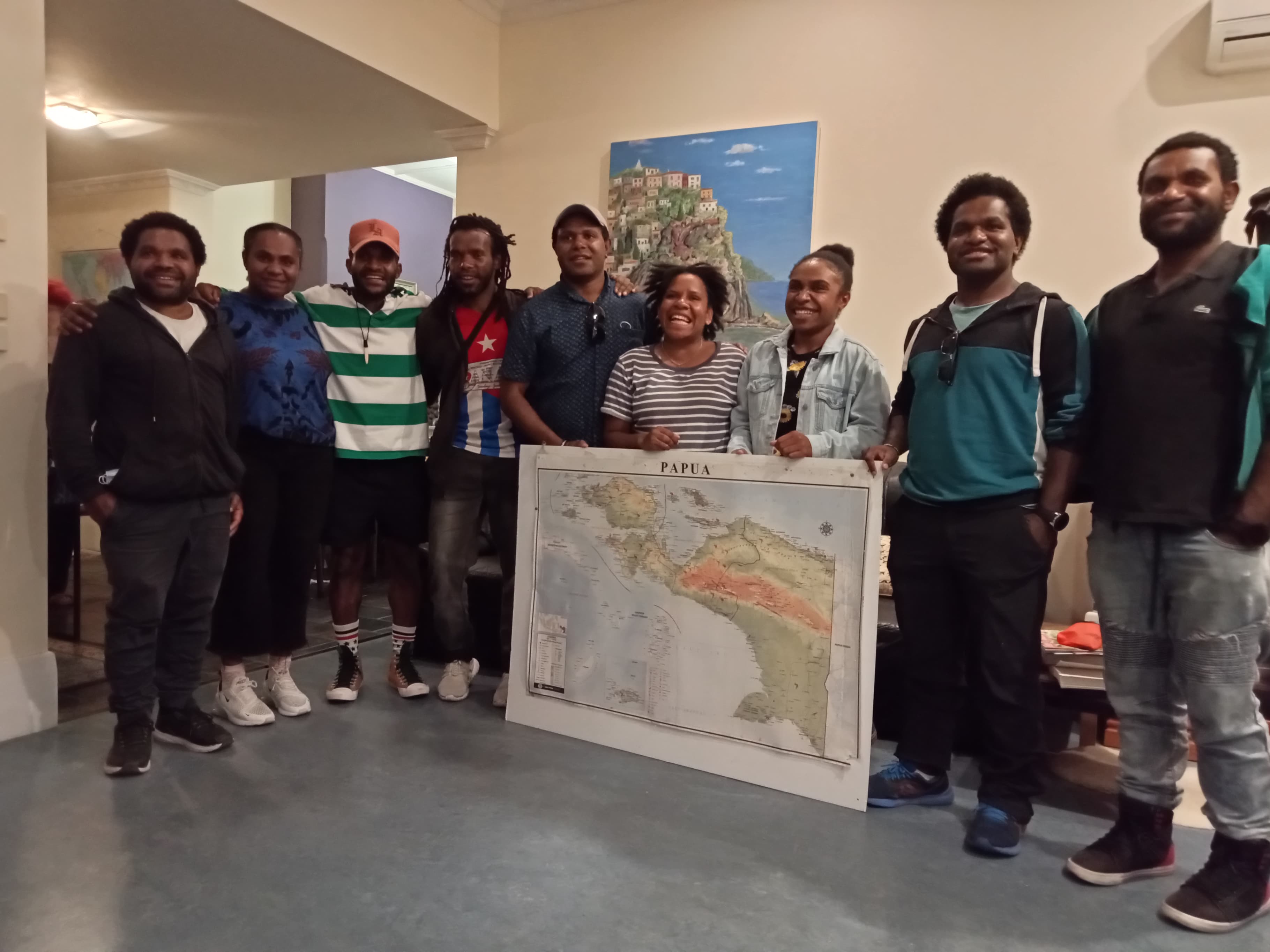 A group of West Papuan students standing with a large map.