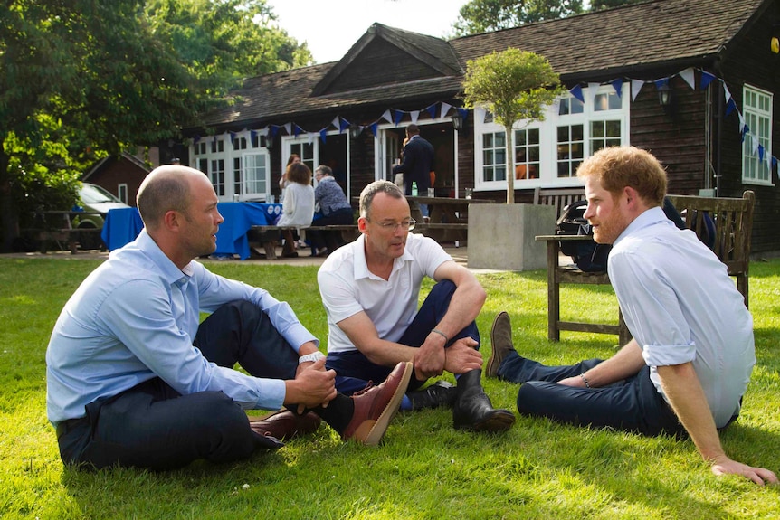 Prince Harry speaks with guests at a Heads Together event.
