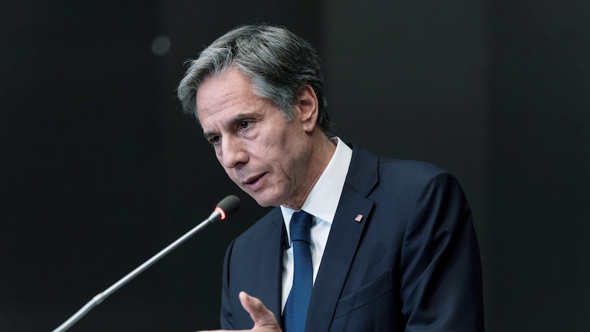 US Secretary of State Anthony Blinken stands at a podium to address reporters in Jordan.