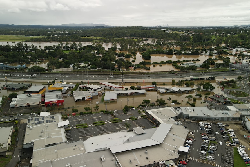A drone shot of Goodna, showing brown floodwaters coming close to the rooves of several buildings.