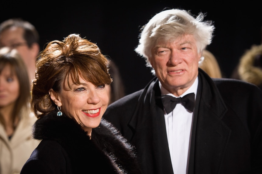 Couple wears black tie on a red carpet