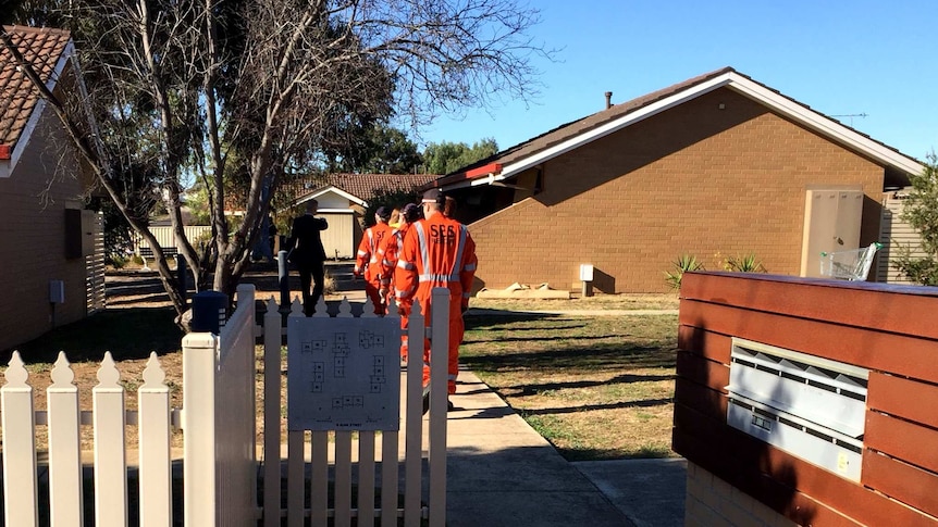 An SES team enter the house where a woman was found dead in Maryborough in central Victoria.