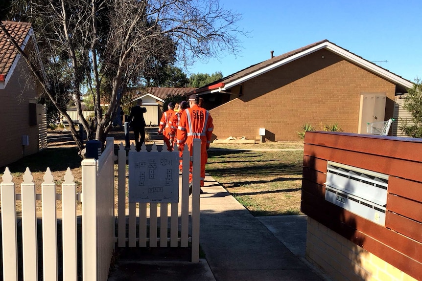 An SES team enter the house where a woman was found dead in Maryborough in central Victoria.