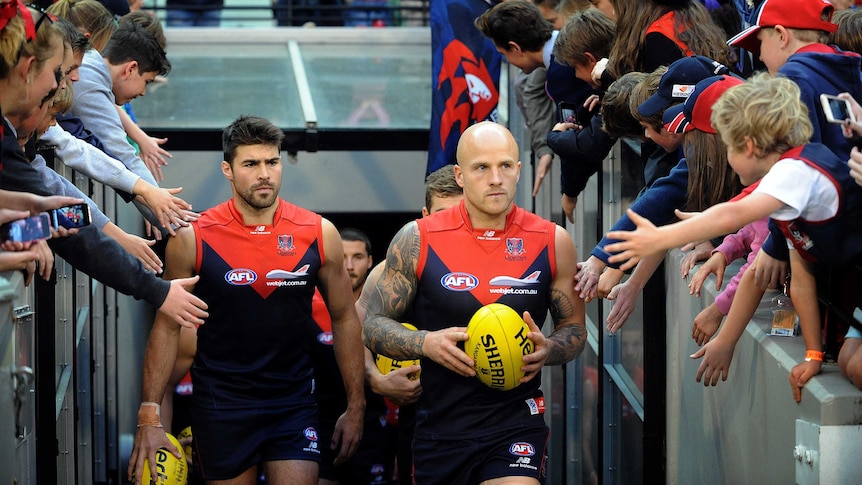 Nathan Jones leads melbourne out for their match against the gold coast suns