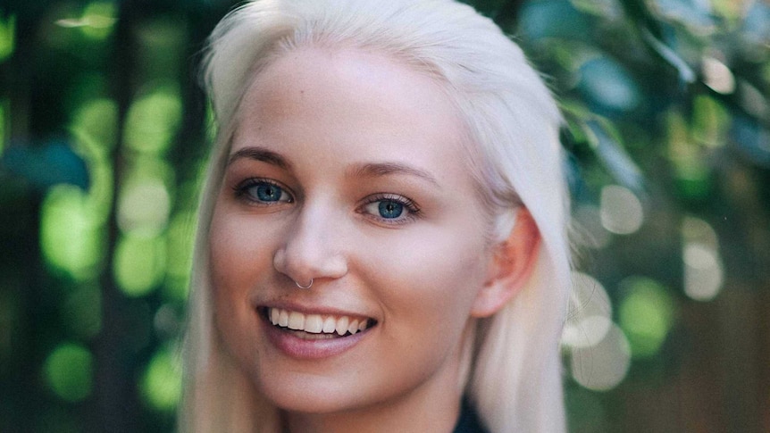 Headshot of a blonde woman smiling to camera.