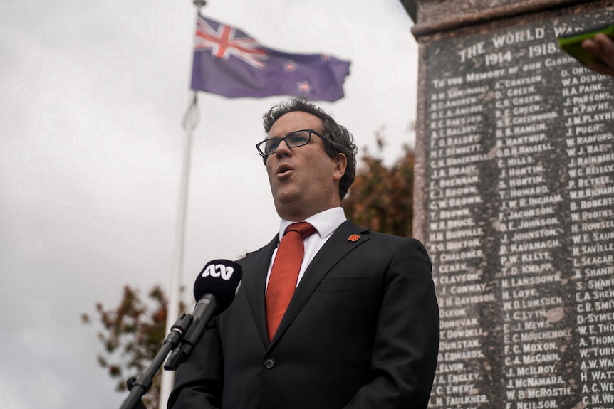 man stands in front of war memorial