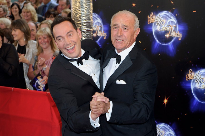 Two men holding hands in a ballroom dancing pose